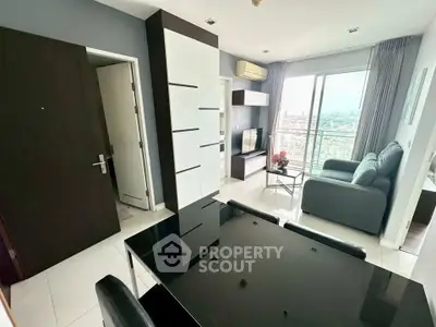 Modern living room with sleek furniture and city view balcony in high-rise apartment.