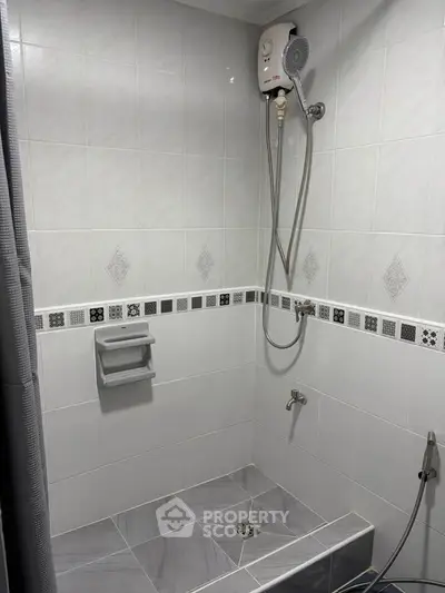 Modern bathroom with sleek tiles and shower unit, perfect for a contemporary home.