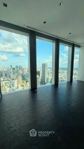 Stunning high-rise apartment with panoramic city views and floor-to-ceiling windows.