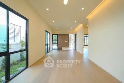 Spacious modern living room with large windows and wooden flooring