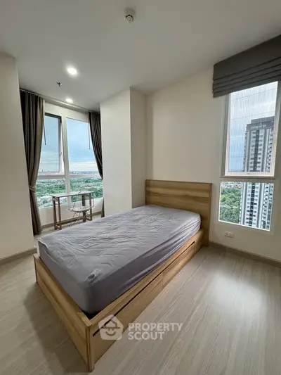 Modern bedroom with large windows offering stunning city views and natural light.