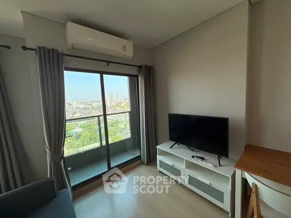 Modern living room with balcony and city view, featuring sleek TV setup and air conditioning.