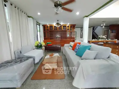 Spacious living room with modern decor and ceiling fan, perfect for family gatherings.