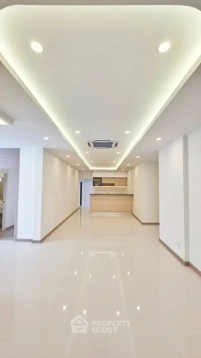 Spacious modern living room with open kitchen layout and recessed lighting