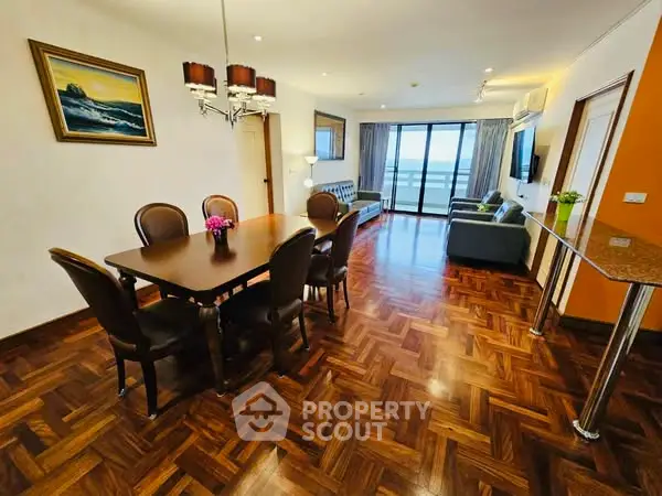 Spacious living room with elegant dining area and stunning balcony view.