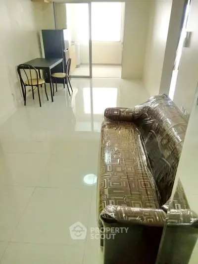 Spacious living room with glossy tiled floors and modern furniture in a bright apartment.