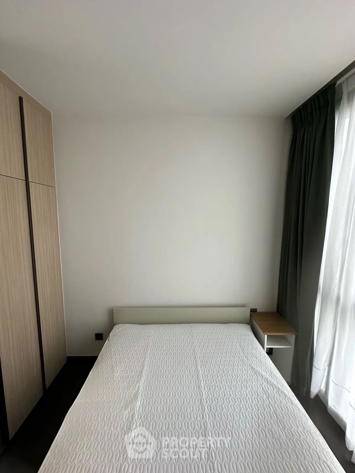 Modern bedroom with minimalist design, featuring a cozy bed and sleek wardrobe, perfect for urban living.
