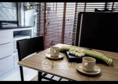 Modern kitchen with sleek design, featuring a wooden dining table and stylish blinds.