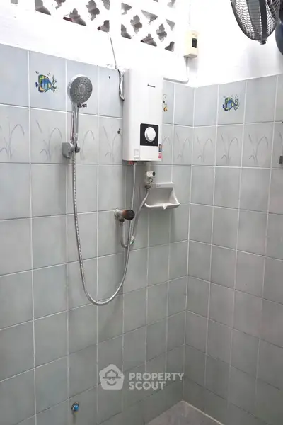 Compact bathroom with tiled walls and modern shower unit
