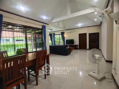 Spacious living room with modern furniture and garden view, perfect for family gatherings.