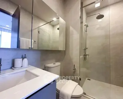 Modern bathroom with glass shower and sleek fixtures in a contemporary home.