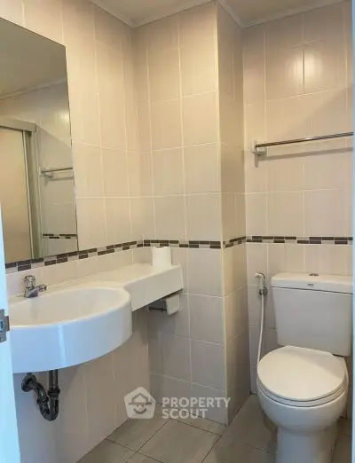 Modern bathroom with sleek fixtures and neutral tiles, perfect for a contemporary home.