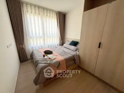 Cozy bedroom with modern decor and large window for natural light