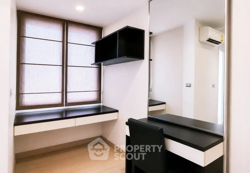 Modern study room with sleek black desk and chair, featuring large window and air conditioning.