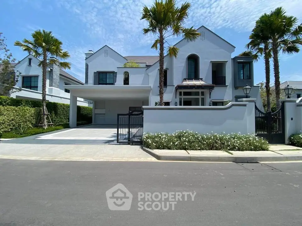 Luxurious modern villa with palm trees and spacious driveway in a serene neighborhood.