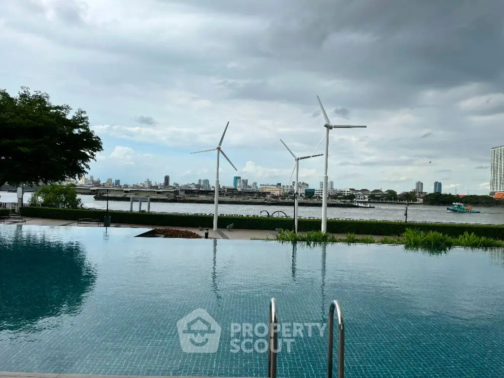 Stunning infinity pool with city skyline and wind turbines view, perfect for luxury living.