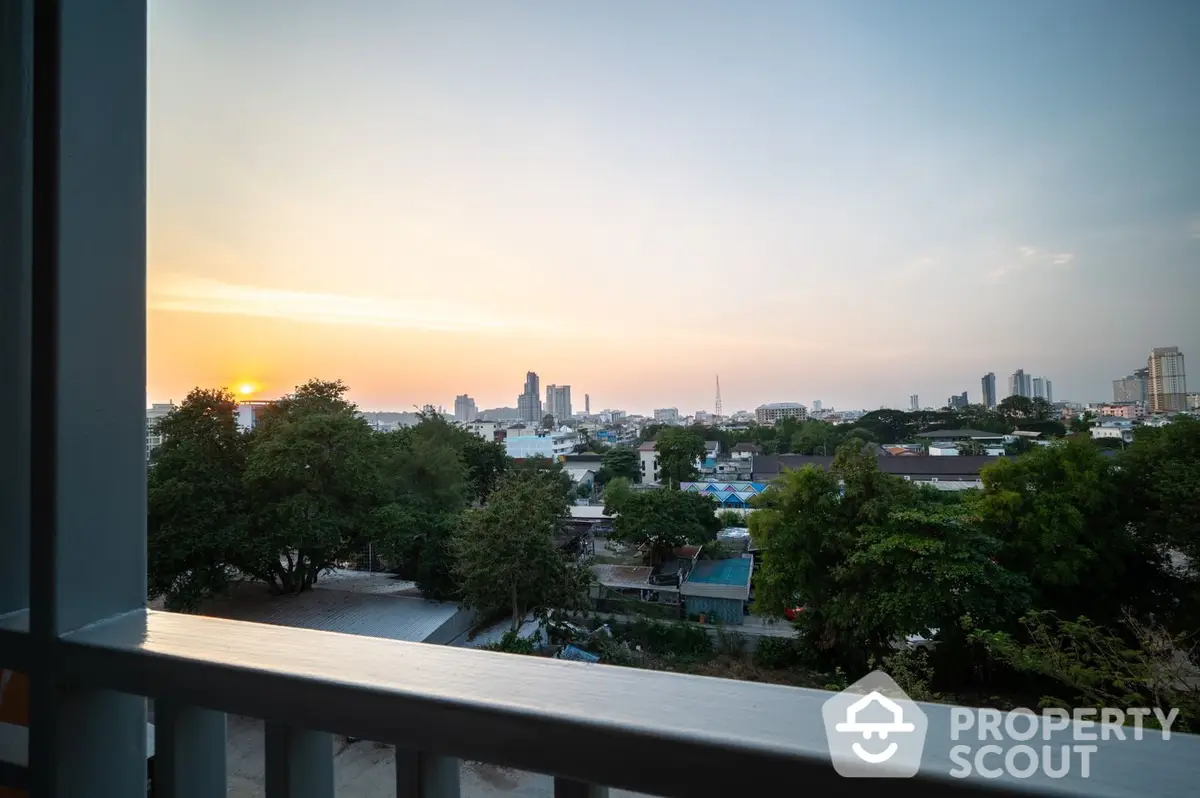 Breathtaking sunset view from a spacious balcony overlooking a serene cityscape, perfect for relaxing evenings in a prime location.