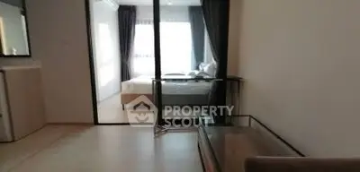 Modern apartment interior with glass partition and cozy bedroom view.