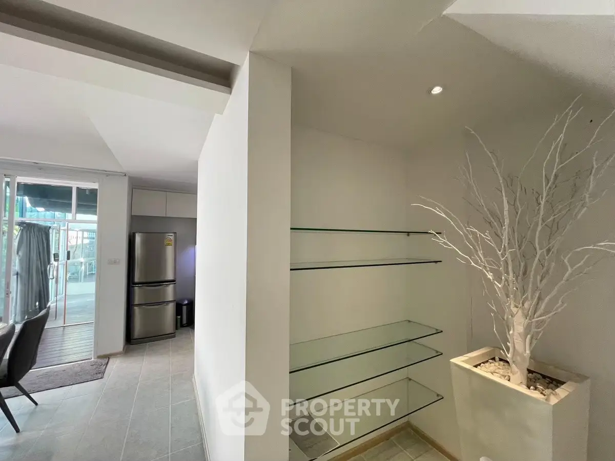 Modern interior with sleek glass shelves and stylish decor in a contemporary apartment.