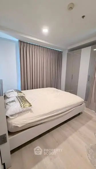 Modern bedroom with sleek design and ample natural light, featuring a comfortable bed and stylish wardrobe.