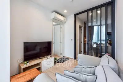 Modern living room with sleek design and open layout, featuring a cozy sofa and large TV.
