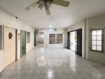 Spacious open-plan living area with tiled flooring and ceiling fan