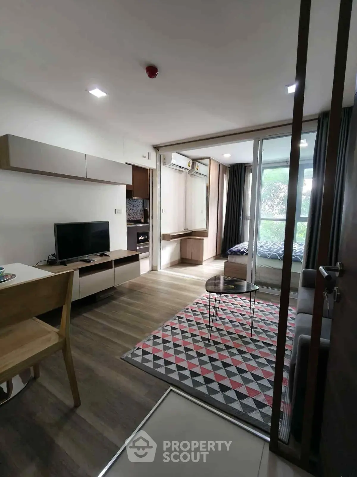 Modern living room with stylish decor and open layout, featuring a cozy seating area and large windows.