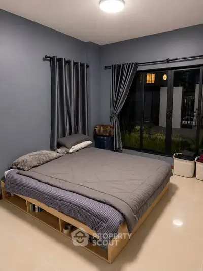 Modern bedroom with sleek design and large window offering natural light