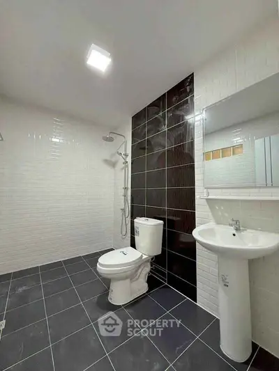 Modern bathroom with sleek black and white tiles and contemporary fixtures.