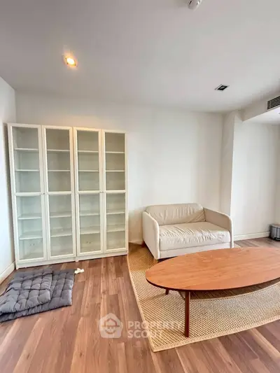 Modern living room with cozy sofa, wooden coffee table, and elegant glass cabinet.