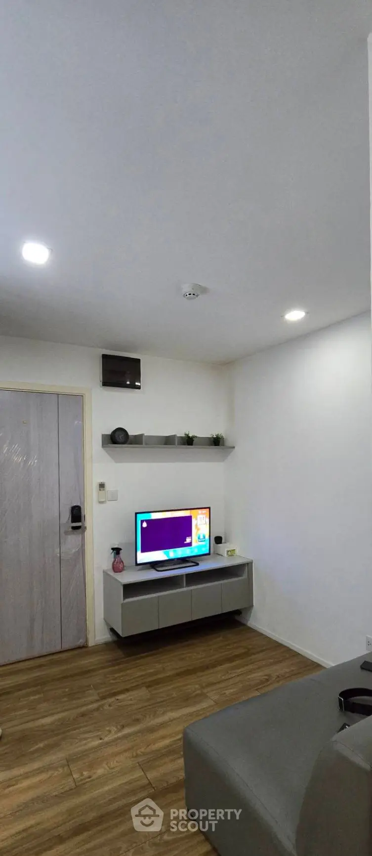 Modern living room with sleek TV setup and wooden flooring