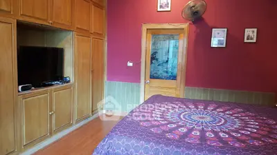 Charming bedroom with vibrant decor and built-in wooden storage cabinets.