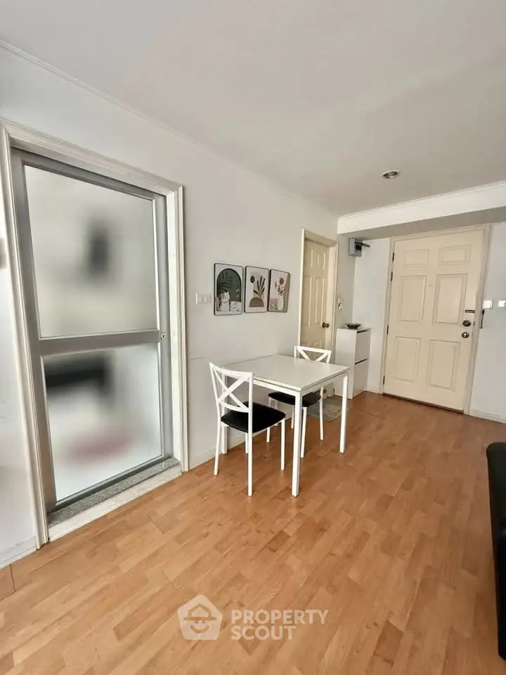 Charming dining area with wooden flooring and modern decor in a cozy apartment.