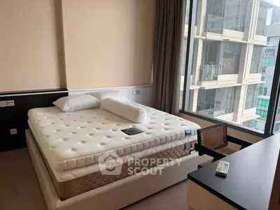 Modern bedroom with large window offering city view, featuring a comfortable bed and sleek furniture.