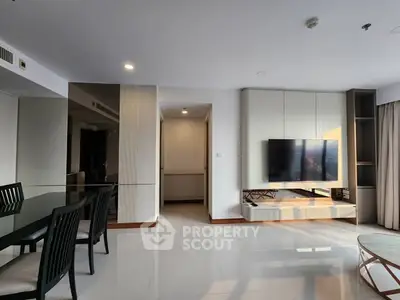 Spacious modern living room with sleek furniture and wall-mounted TV, perfect for relaxation and entertainment.