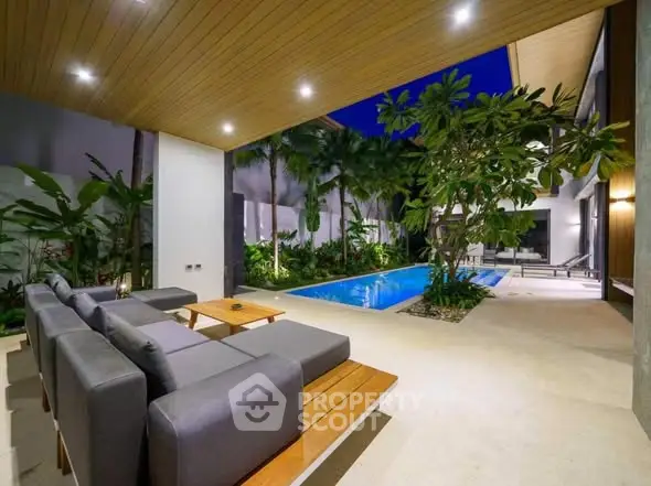 Luxurious outdoor patio with modern seating and pool surrounded by lush greenery, perfect for relaxation.