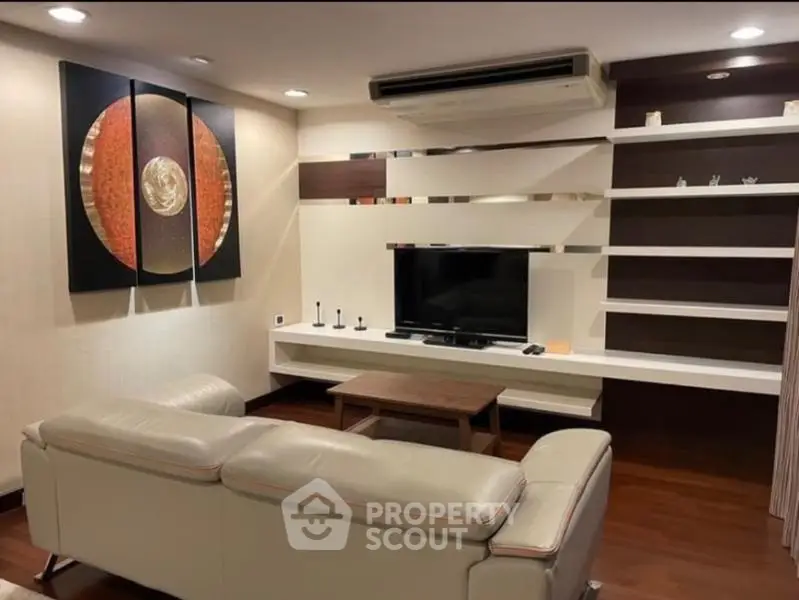 Modern living room with sleek furniture and stylish wall art, featuring a cozy ambiance.