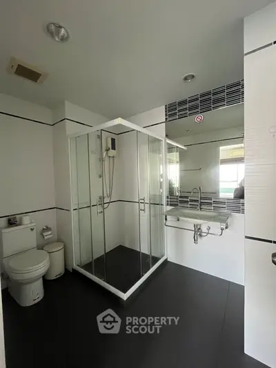 Modern bathroom with glass shower enclosure and sleek fixtures