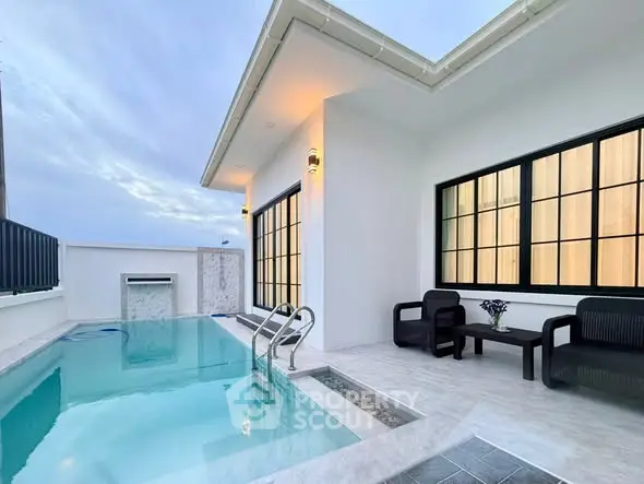 Modern home with private pool and stylish outdoor seating area at sunset.
