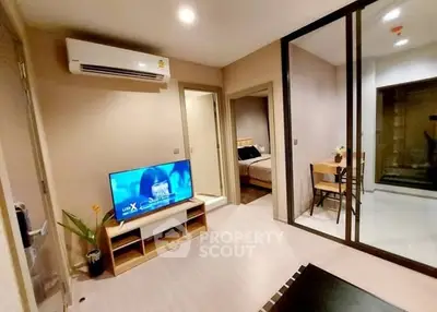 Modern living room with TV and air conditioning, adjacent to bedroom and dining area.