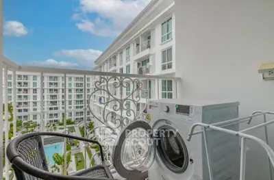 Modern apartment balcony with washing machine and pool view