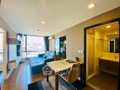 Modern living room with open layout and city view, featuring a stylish sofa and dining area.