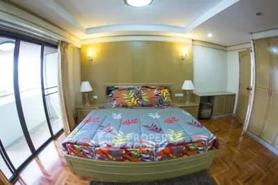 Spacious bedroom with balcony access and stylish decor in modern apartment.