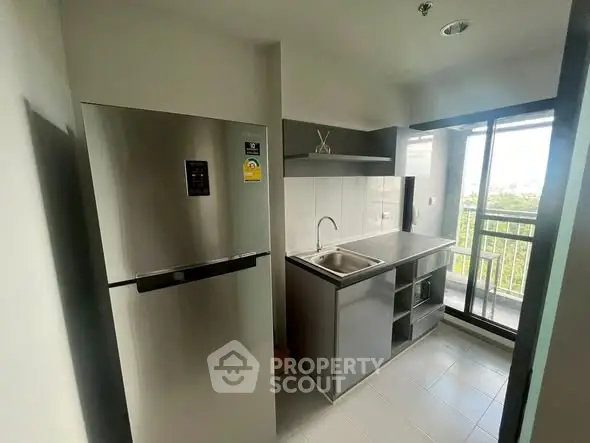 Modern kitchen with stainless steel fridge and balcony view