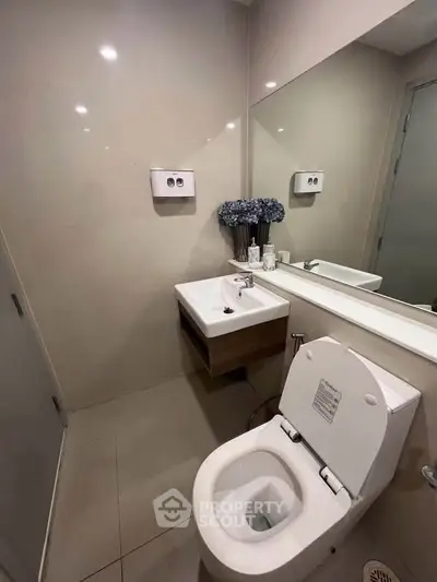 Modern bathroom with sleek fixtures and elegant design, featuring a wall-mounted sink and stylish decor.