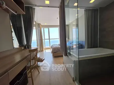 Modern apartment with ocean view, featuring a cozy bedroom and luxurious bathtub.