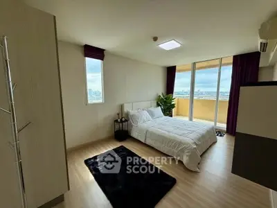 Spacious bedroom with city view and balcony access in modern apartment