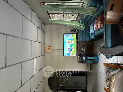 Cozy living room with tiled floor, comfortable seating, and wall-mounted TV, perfect for relaxation.