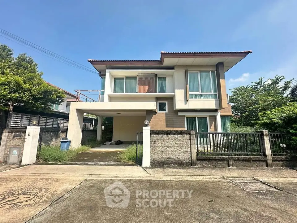 Modern two-story house with spacious driveway and lush greenery, perfect for family living.