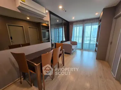 Modern living room with dining area and large windows in a stylish apartment.